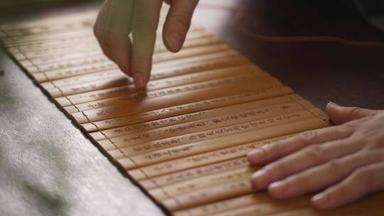 古代文人打开竹简学习中国传统文学论语