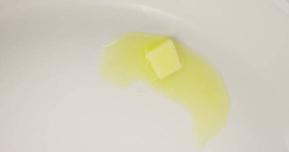 4K俯视一块黄油在热锅内融化