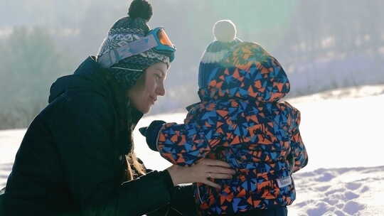 玩雪的女人和蹒跚学步的孩子