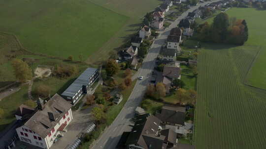 一辆汽车驶过村庄的鸟瞰图。DJI Mavic