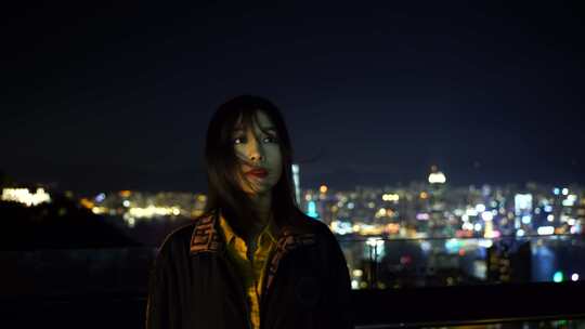 夜晚游客女性站在太平山顶上看香港夜景风景