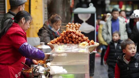 成都锦里游客路过街头小吃摊