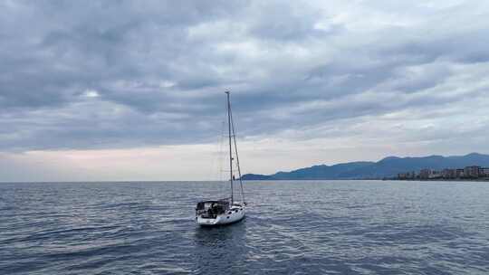 日落时分，帆船停泊在海湾中，水清澈碧绿