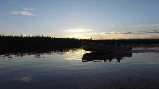 日落时在湖上航行的船