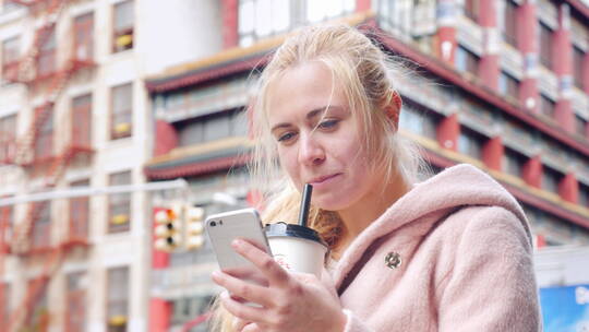 游客在美国纽约唐人街喝奶茶玩手机
