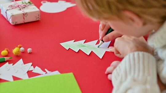 儿童用铅笔给剪纸圣诞树上色视频素材模板下载