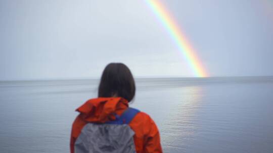 女人在海边独自观赏彩虹
