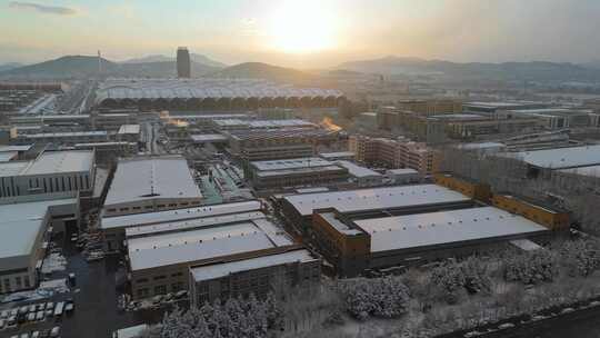 冬季航拍大雪中的城市建筑逆光晚霞风景