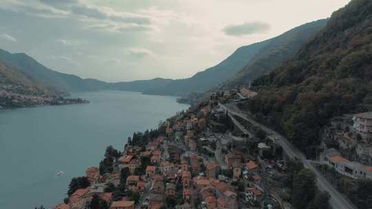 美丽的空中飞行缓慢沿着科莫湖岸边在托里吉亚显示房屋道路，阿尔卑斯山