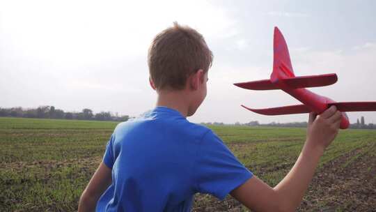 男孩拿着玩具飞机向前奔跑