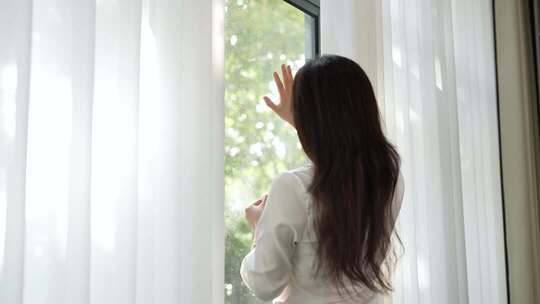 女生触摸阳光看窗外