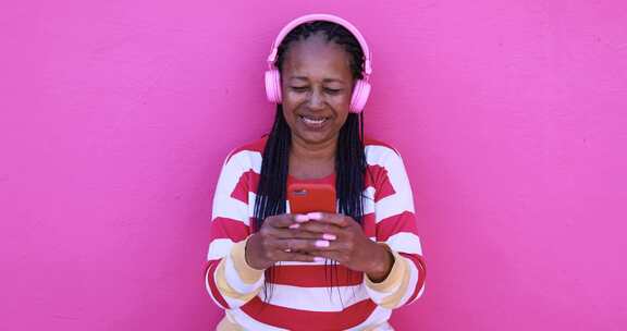 来自智能手机应用程序的资深非洲女性收听音乐播放列表