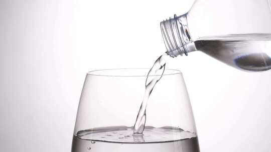 从塑料瓶将水倒入玻璃杯