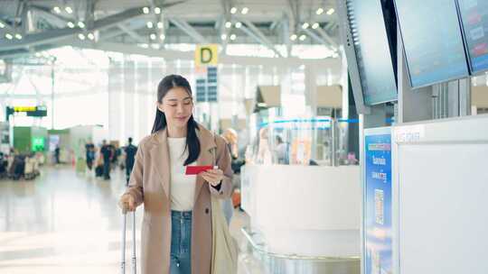 亚洲年轻女子旅客在机场检查登机牌。