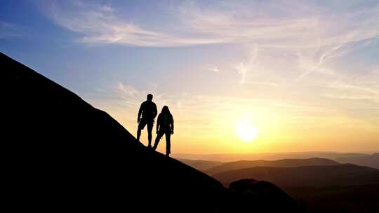 情侣夕阳下登山剪影背影