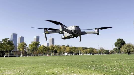 城市公园大草坪上空正在拍摄的无人机