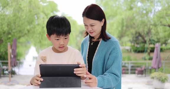 妈妈辅导孩子学习使用平板电脑上网课