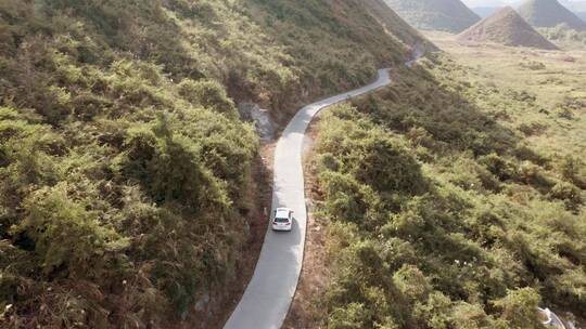 航拍白色汽车行驶崎岖山路