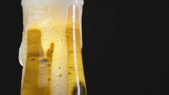 啤酒从杯中溢出气泡