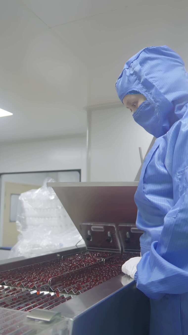 工人操作流水线进行药品生产