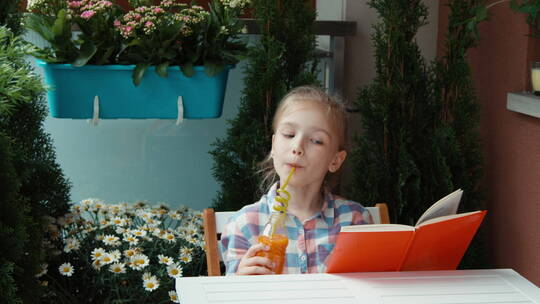 女孩喝着果汁读书