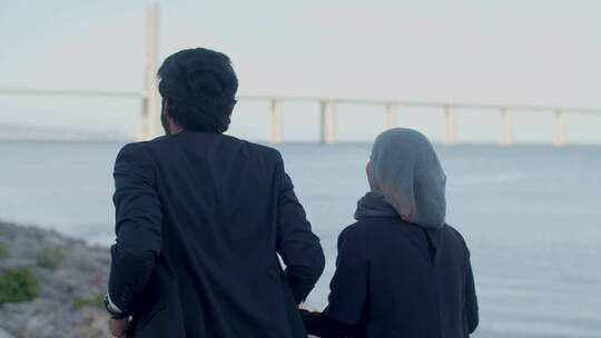 幸福的阿拉伯夫妇沿河奔跑的背影