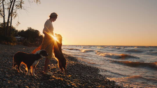 一个女人和她的狗在海边玩耍