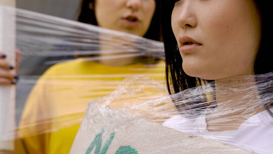 女人用塑料膜包裹女孩的特写镜头视频素材模板下载