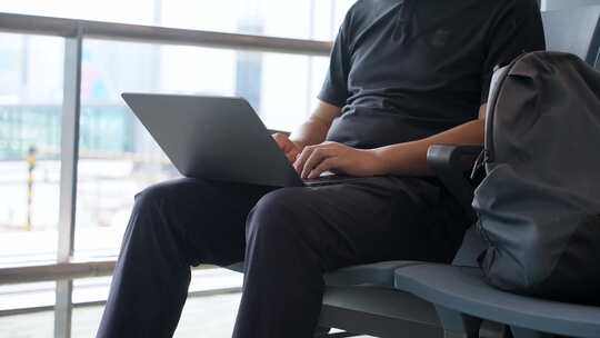 商务男子出差途中机场用笔记本电脑移动办公