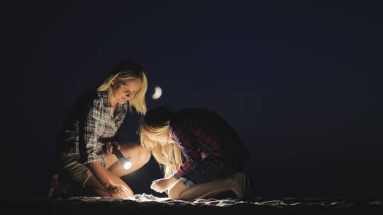 夜晚母女在沙滩上玩耍