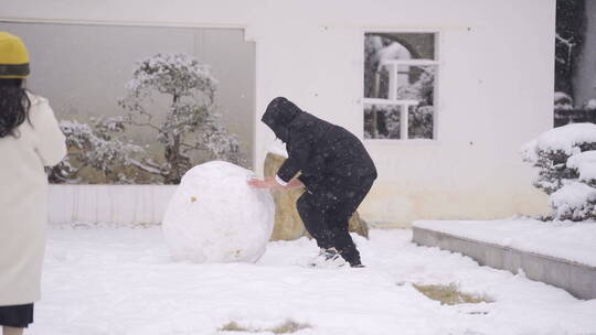 情侣在院子里滚雪球