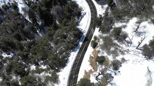 跟着一辆汽车沿着积雪的蜿蜒山路