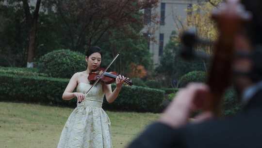 美女小提琴和外国人大提琴草坪演奏