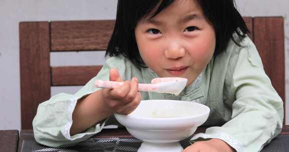 可爱小女孩开心的吃豆腐花微笑甜蜜