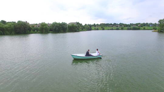 情侣在池塘上划船