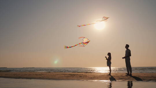 爸爸和女儿在海滩上玩风筝视频素材模板下载