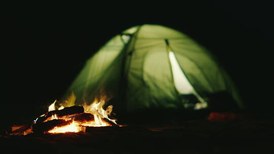 燃烧的篝火旁搭着帐篷