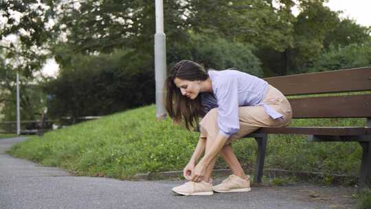 一个美丽的年轻高加索女人坐在公园的长凳上