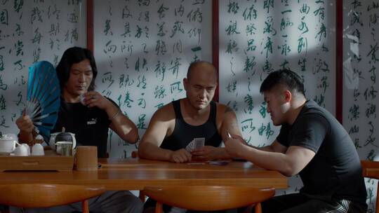 三个男人在打牌喝茶