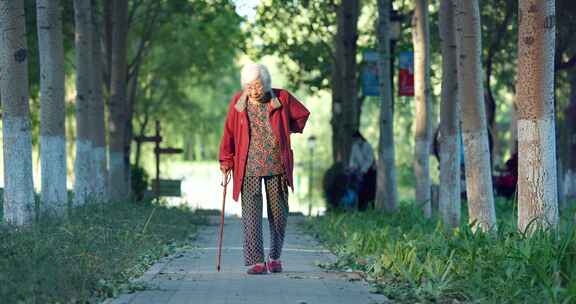 老人老年女性拄着拐杖在公园散步