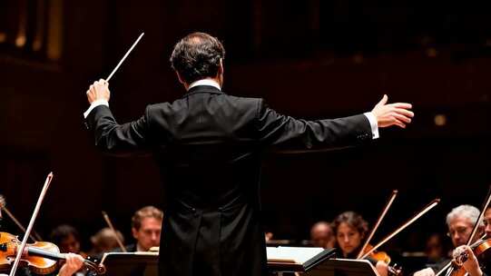 指挥家指挥交响乐团演奏场景