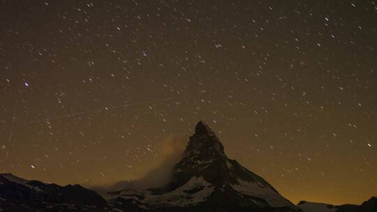 夜晚雪山上的夜空星轨天文