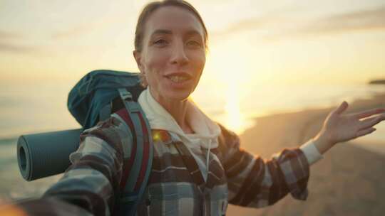 女游客用旅游背包录音制作海上日落女徒步旅