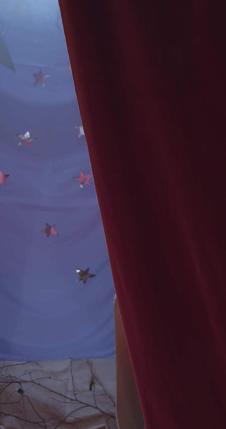 穿着骑士服装的男孩透过窗帘看