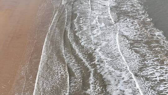 航拍俯瞰威海金海湾海水浴场的沙滩海浪