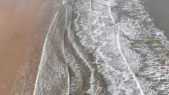 航拍俯瞰威海金海湾海水浴场的沙滩海浪视频素材模板下载