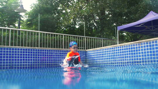 可爱小男孩跳入游泳池潜水玩耍