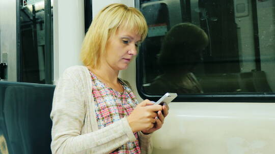 妇女在地铁使用智能手机