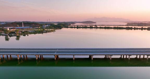 航拍夕阳下穿过鄱阳湖的乡间高速公路