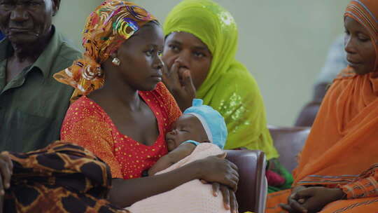 非洲怀抱婴儿的妇女在室内聚集